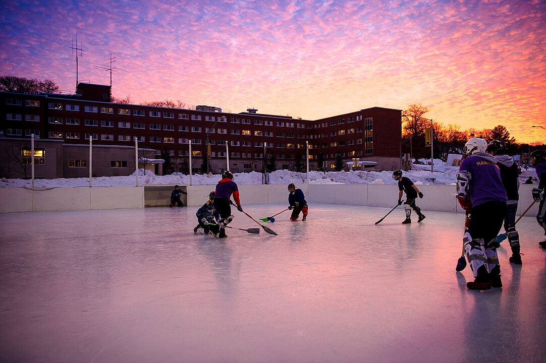 Kids playing broomball on an outdoor rink