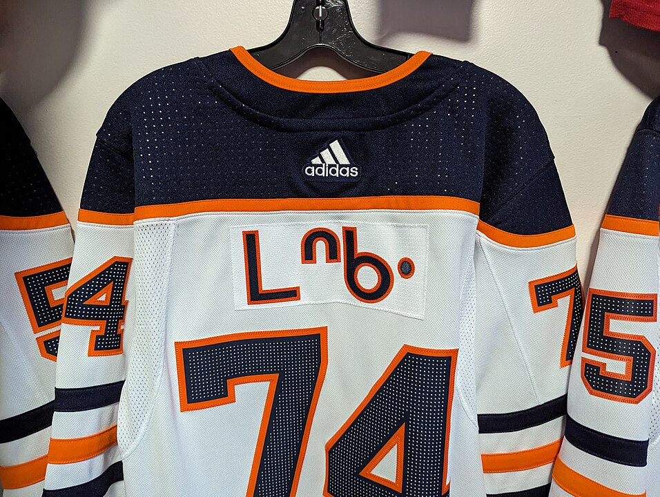 A white, orange, and navy blue hockey jersey