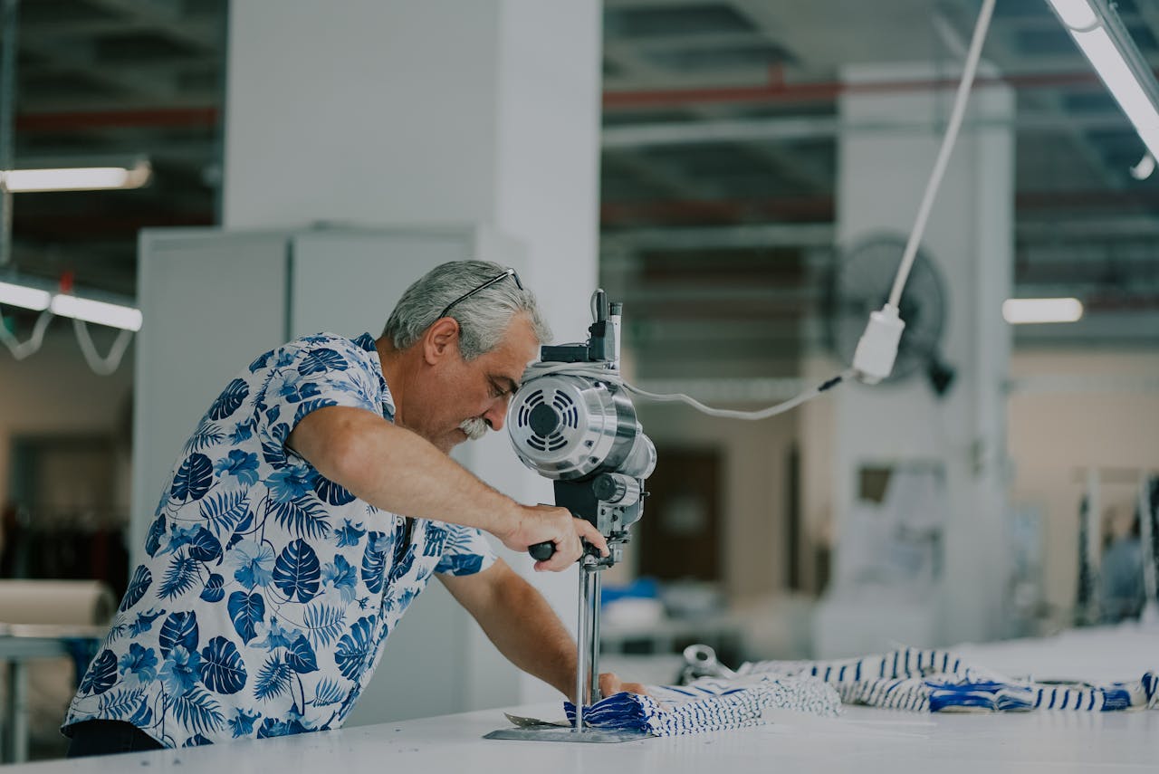 Man using a machine on a pile of fabric